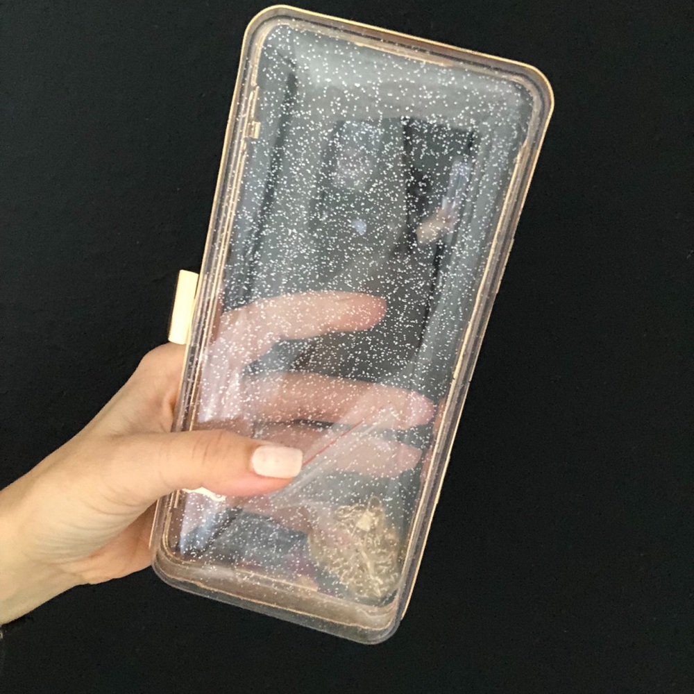 Clear sparkly clutch bag with gold trim.